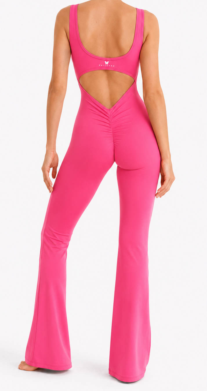 Person wearing a bright pink jumpsuit with cut-out design on a white background