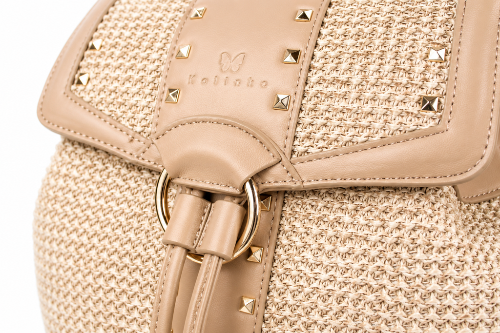 Close-up of a beige woven bag with tan leather trim, gold-tone studs, and a drawstring closure. The brand name 'Meltabo' is embossed on the leather flap.