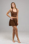 Woman wearing a brown outfit on a gray background