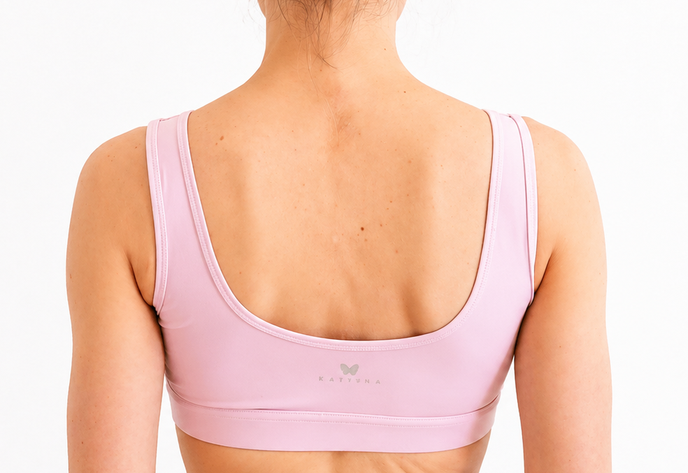 Pink sports bra worn by a person on a white background