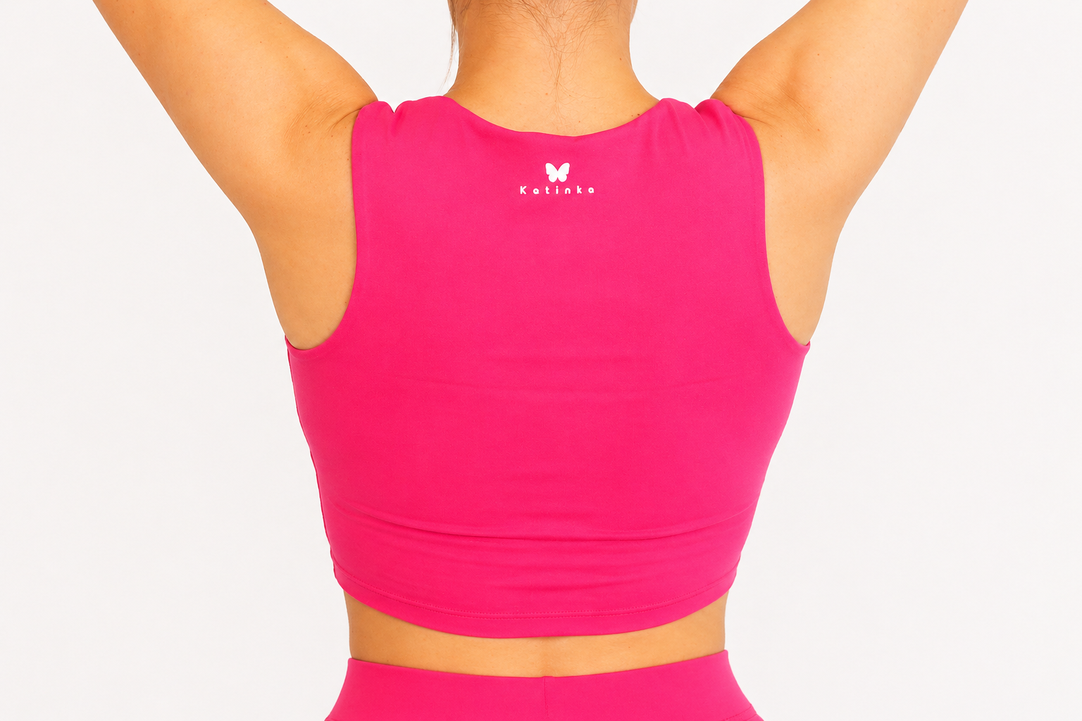 Pink athletic top with a brand logo on a white background